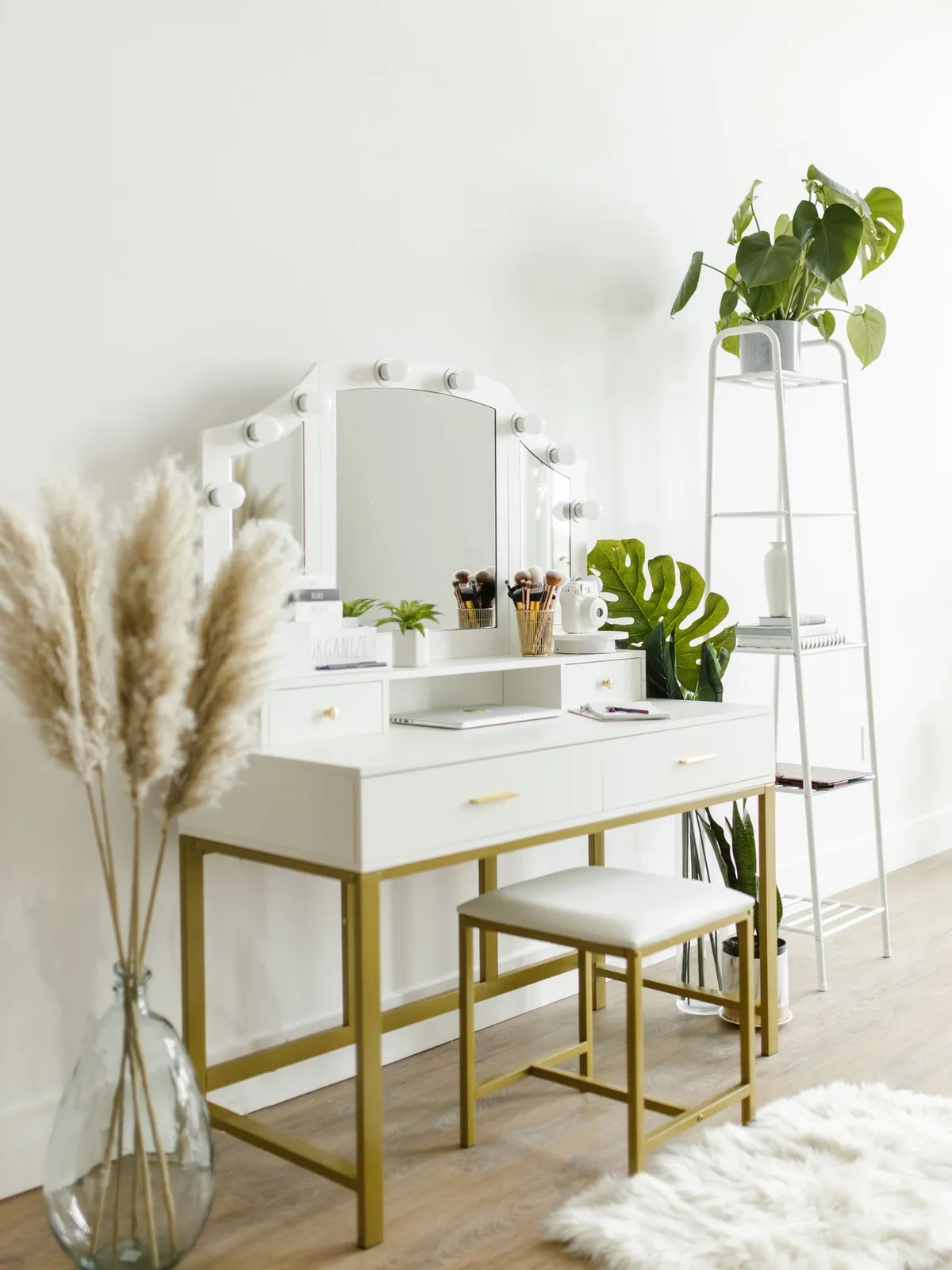 Witte kaptafel met verlichte make-up spiegel, kwasten en een krukje