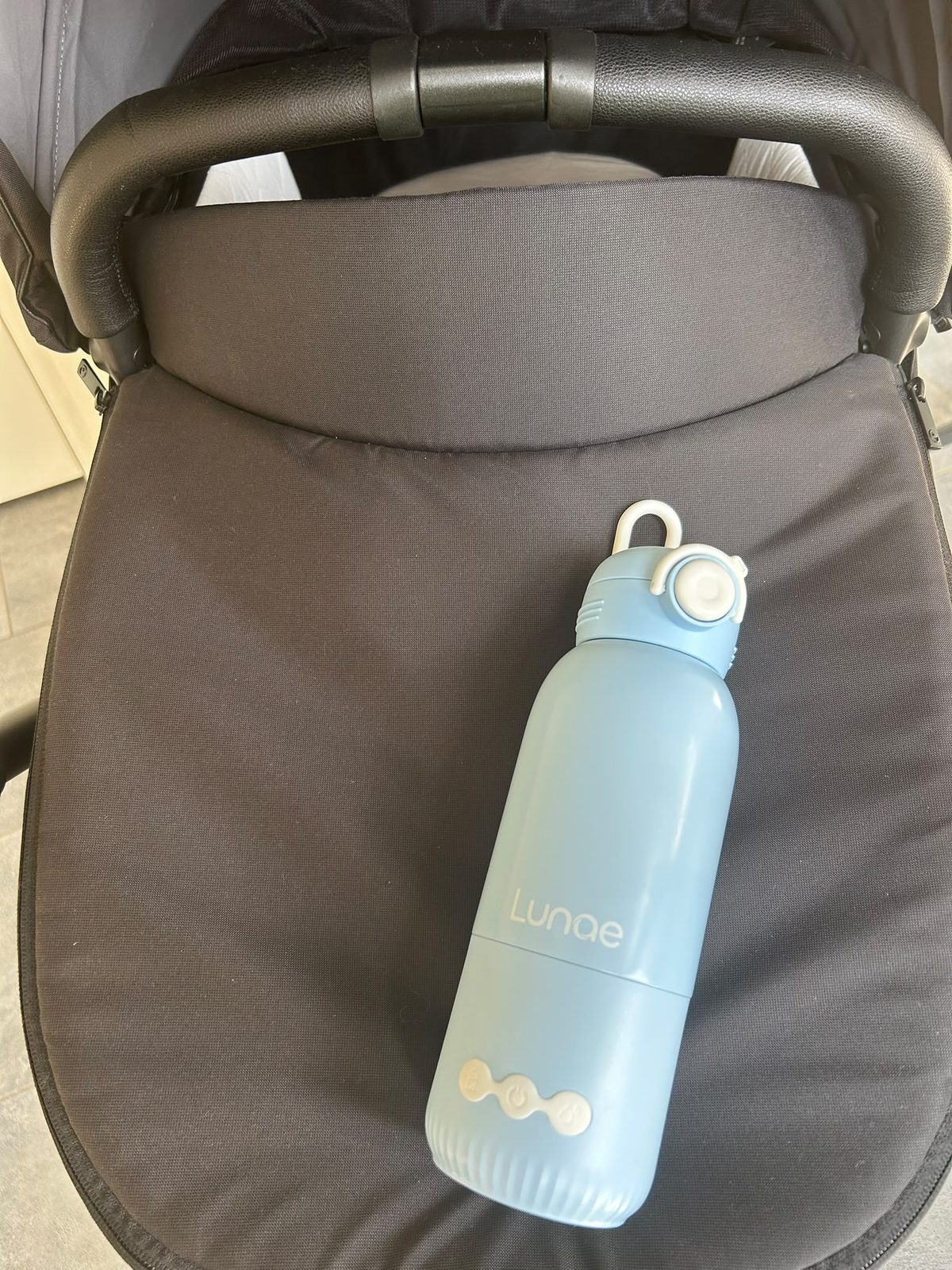 Lunae draagbare flessenwarmer op het matrasje van een kinderwagen