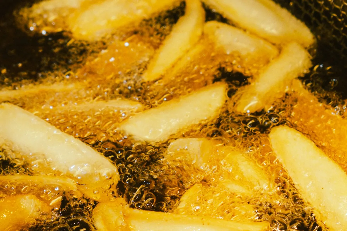 Friet bakt borrelend in hete frituurolie
