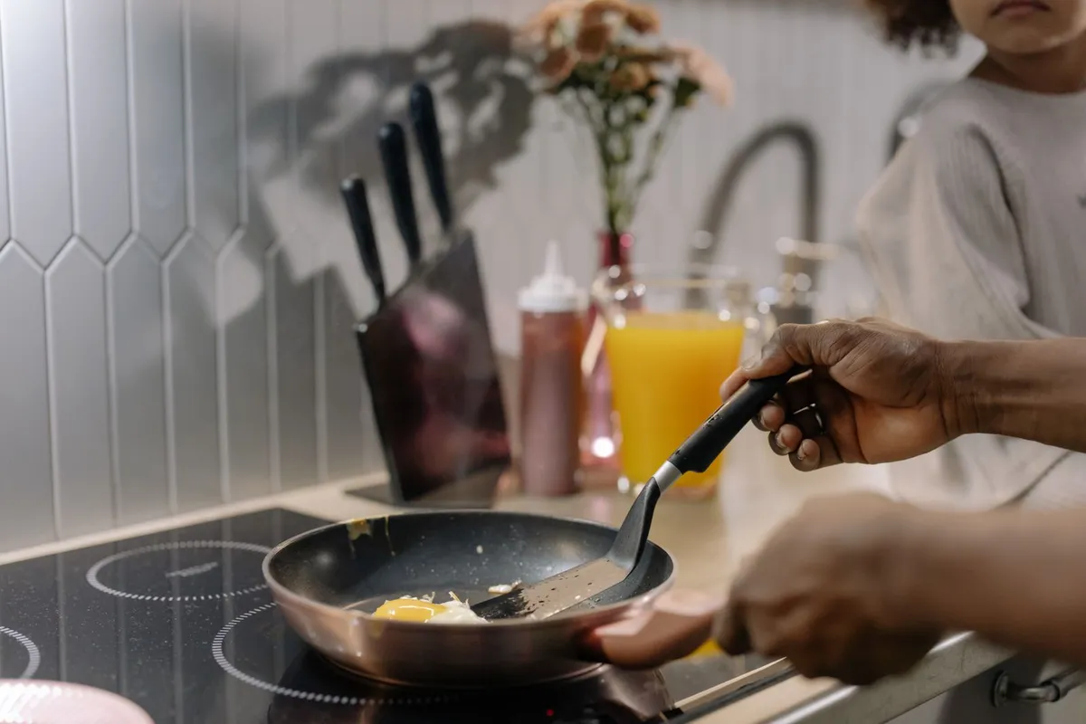 Eieren bakken in een koekenpan op een glazen inductiekookplaat in een moderne keuken